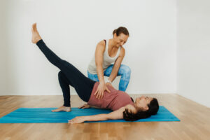 Ursula macht Beckenbodentraining mit einer Kundin in der einbeinigen Schulterbrücke